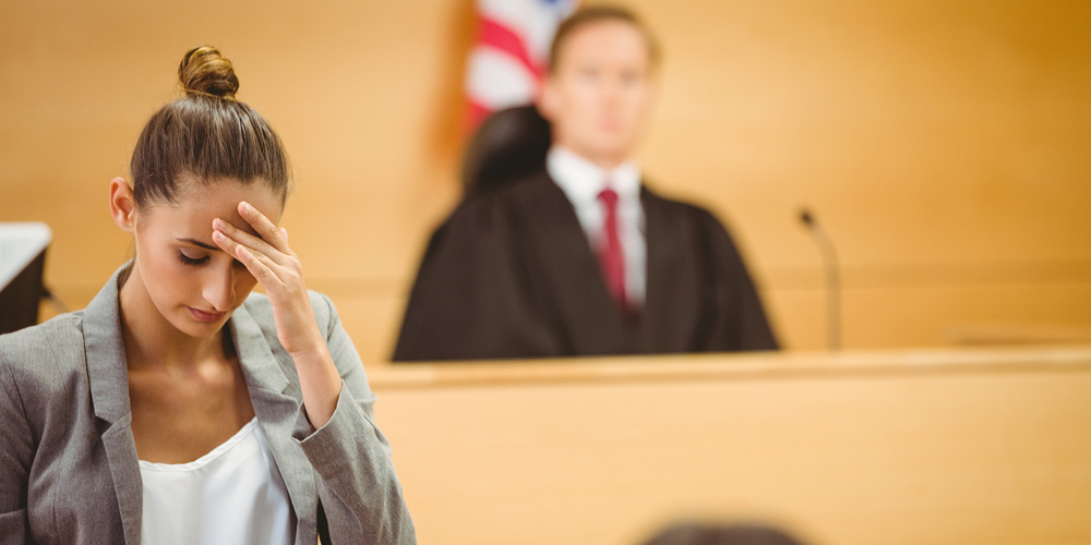 Stressed lawyer with head bowed in the court room